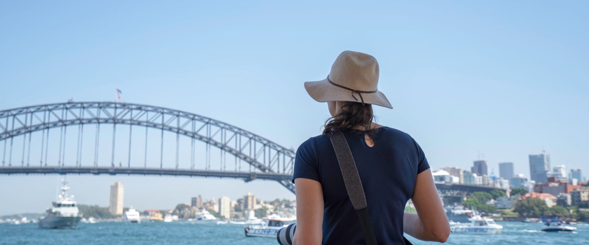 Sydney_lady-on-ferry-with-hat-on-looking-at-the-view-of-s-2023-11-27-05-37-25-utc